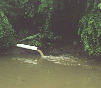 Photo showing a drain dropping water into a stream or river.