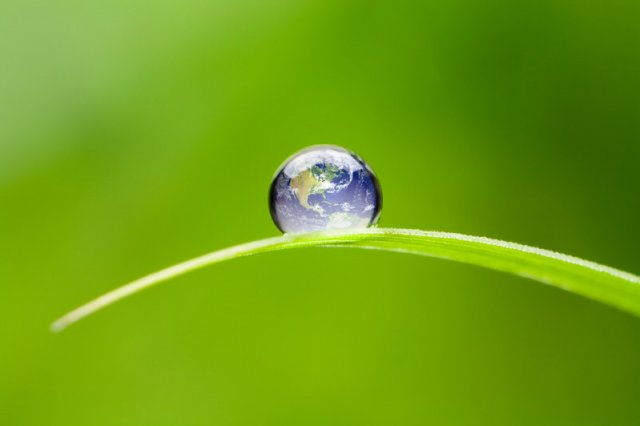 Image of Earth as a water droplet on a blade of grass.