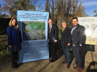 Partnership members and the sign -- A Partnership Committed to Protecting the Environment