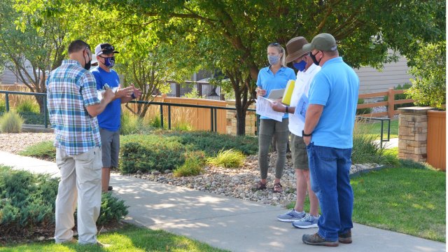 People on a yard conducting a landscape consultation.