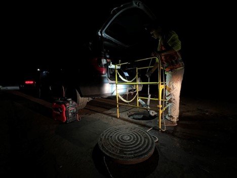 Photo 1: A CCTV camera being lowered into a manhole during EPA night operations to clear nad inspect the sewer lines in Lahaina.