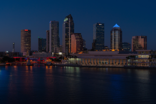 Nighttime in a city with tall buildings next to water