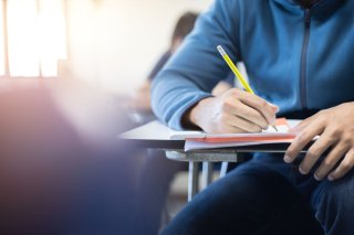 person writing at school desk