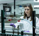 EPA researcher standing in front of an EPA test pilot for testing premise plumbing. 